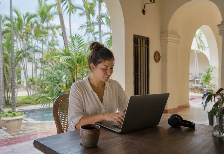 Junge Remote-Arbeiterin in einem hellen Café in Mexiko